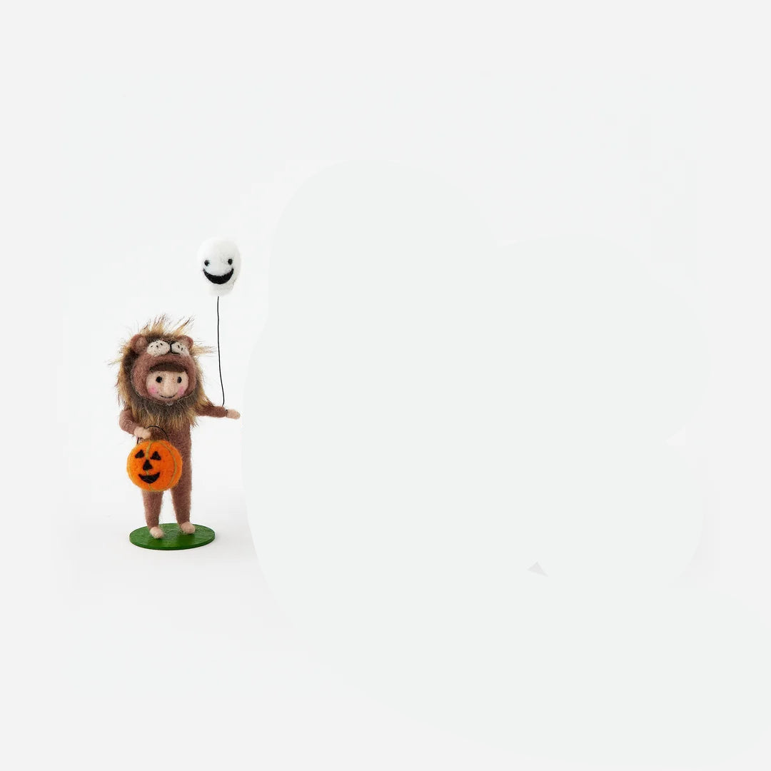 small felt figurine a child dressed in lion costume holding a white ghost balloon