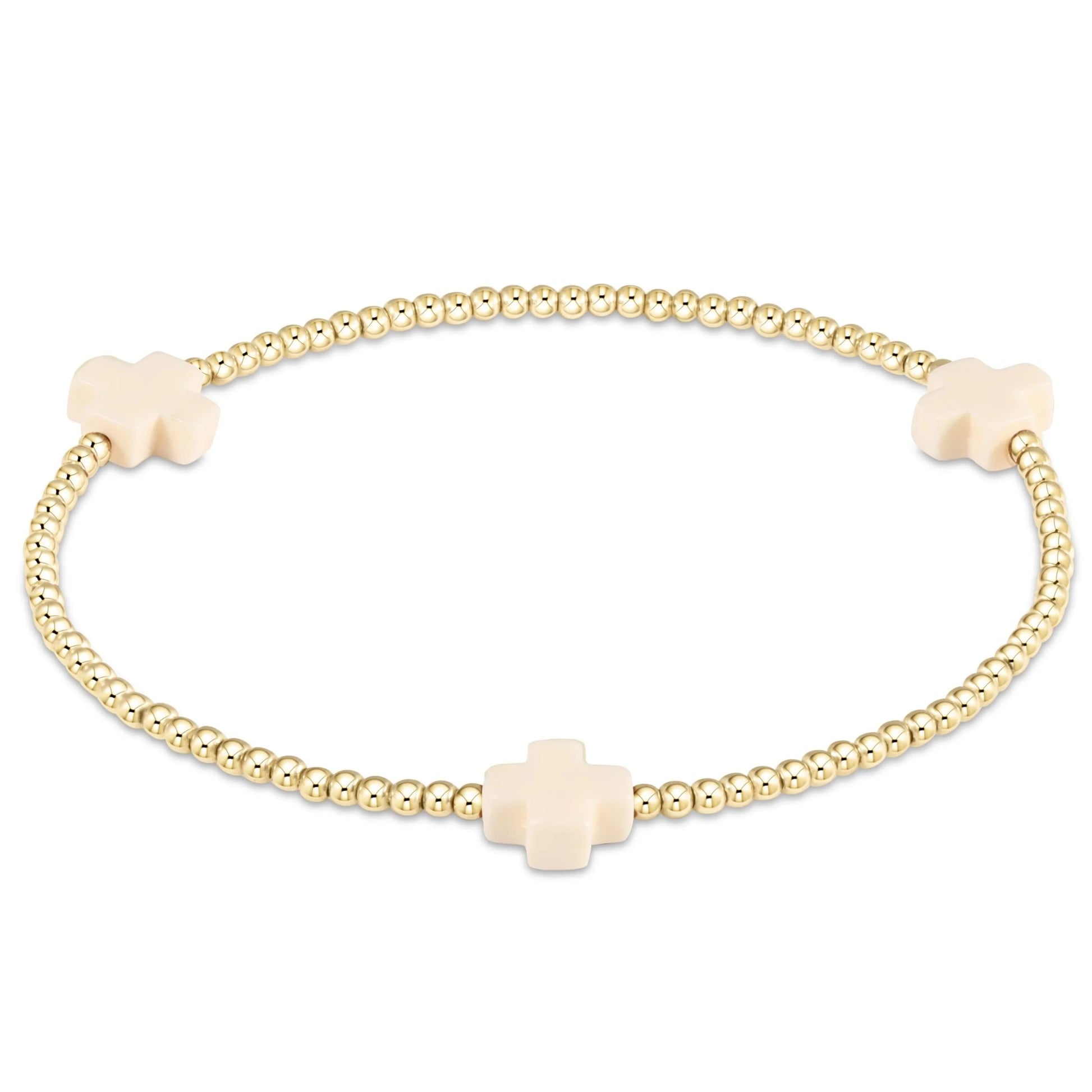 gold beaded bracelet with off-white cross beads
