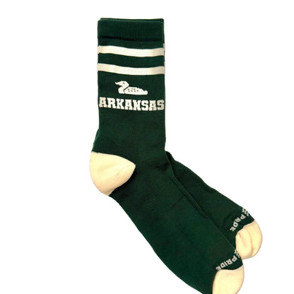 Green socks with a duck and 'ARKANSAS' text on a marble surface