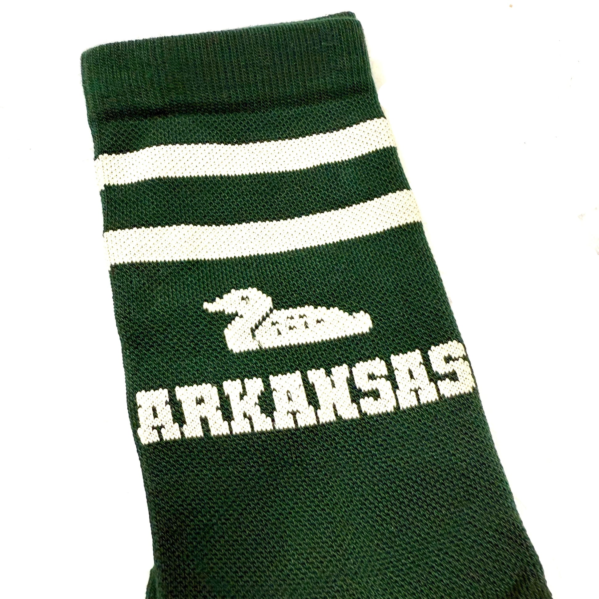 close-up of Green sock with white stripes, a duck, and 'ARKANSAS ' text on a light background