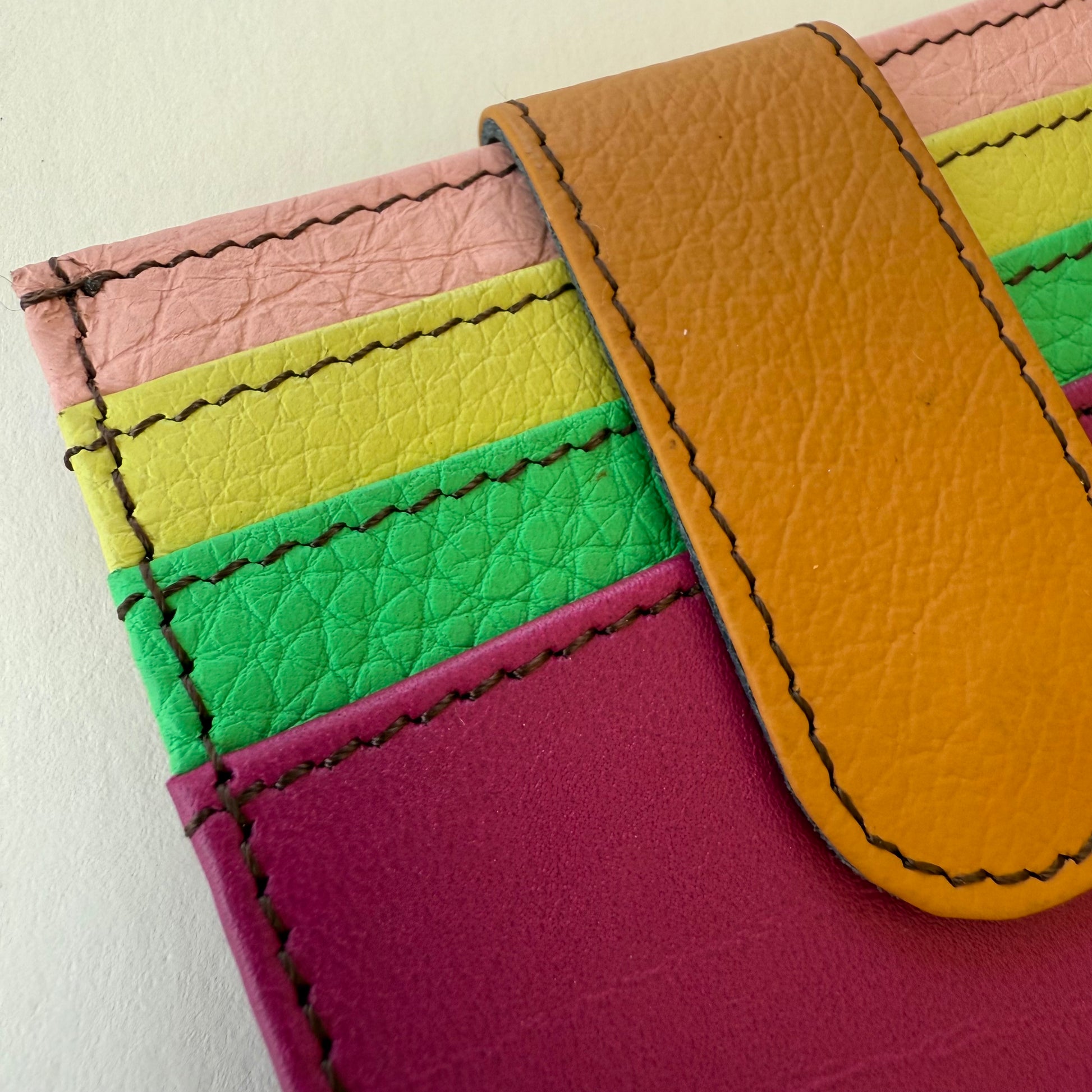 close-up of Colorful leather wallet with multiple card slots on a light background
