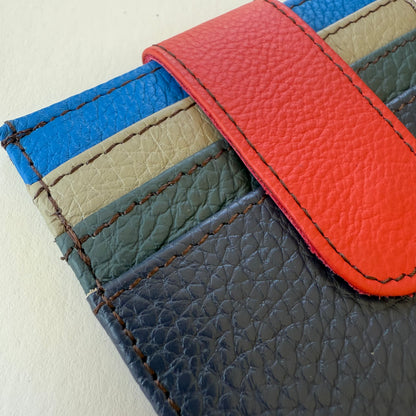 Close-up of a leather wallet with card slots in shades of blues and a orange flap closure