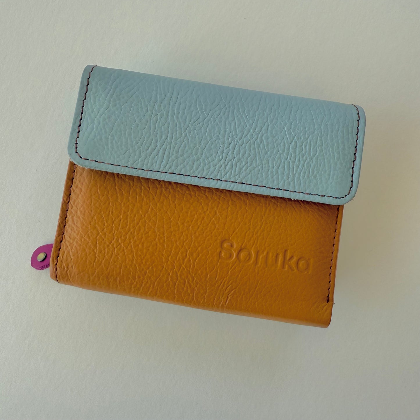 Two-tone wallet with light blue top section and brown bottom section on a white background