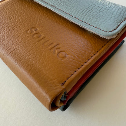 Close-up of a brown leather wallet with light blue flap  on a light background