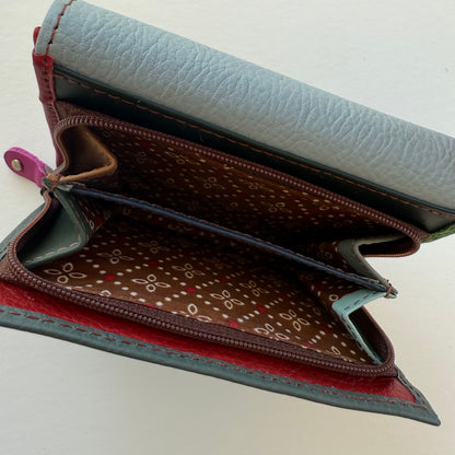 Open view of coin pouch on back of wallet with patterned interior on a light background