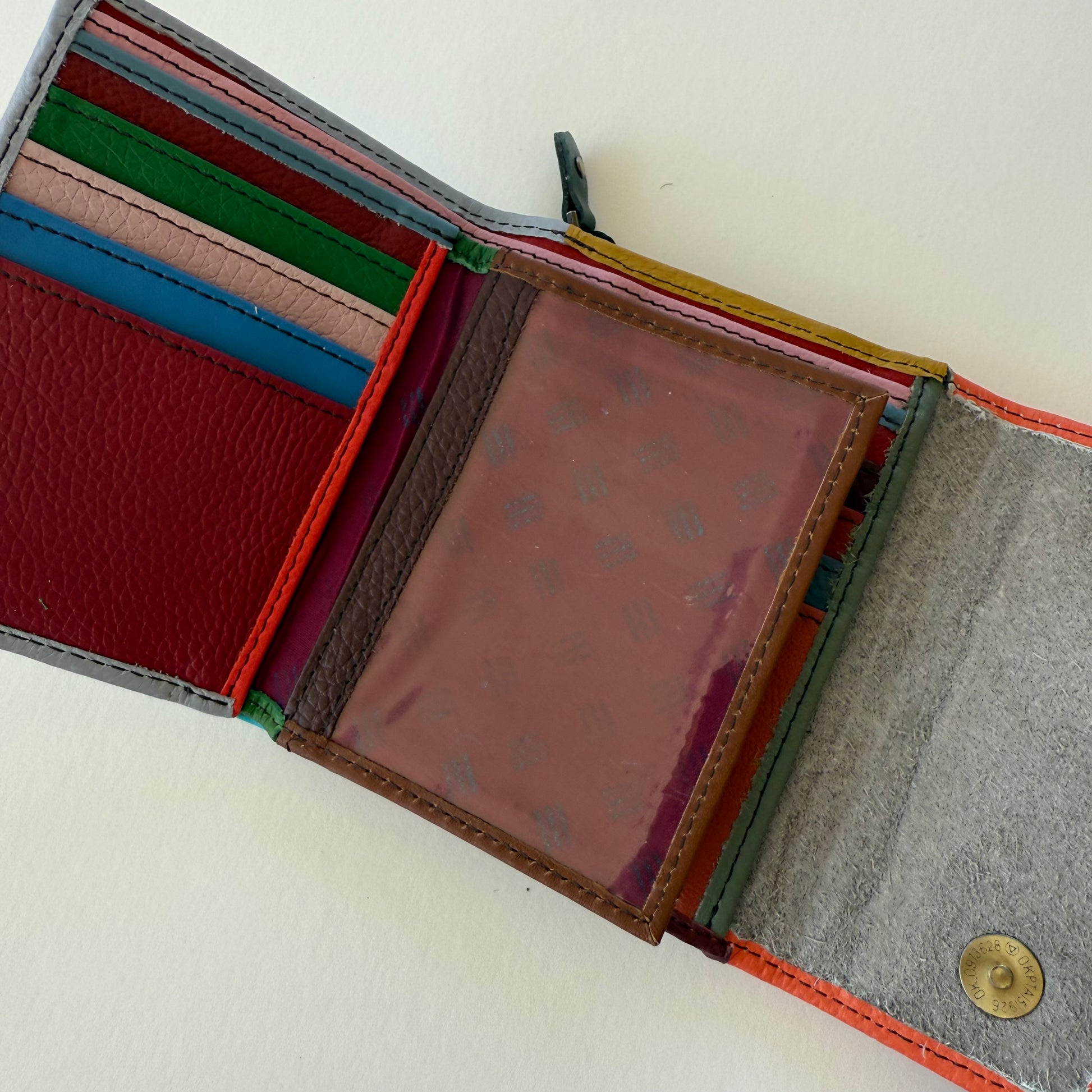 Multicolored wallet with various card slots and clear ID pocket on a white background