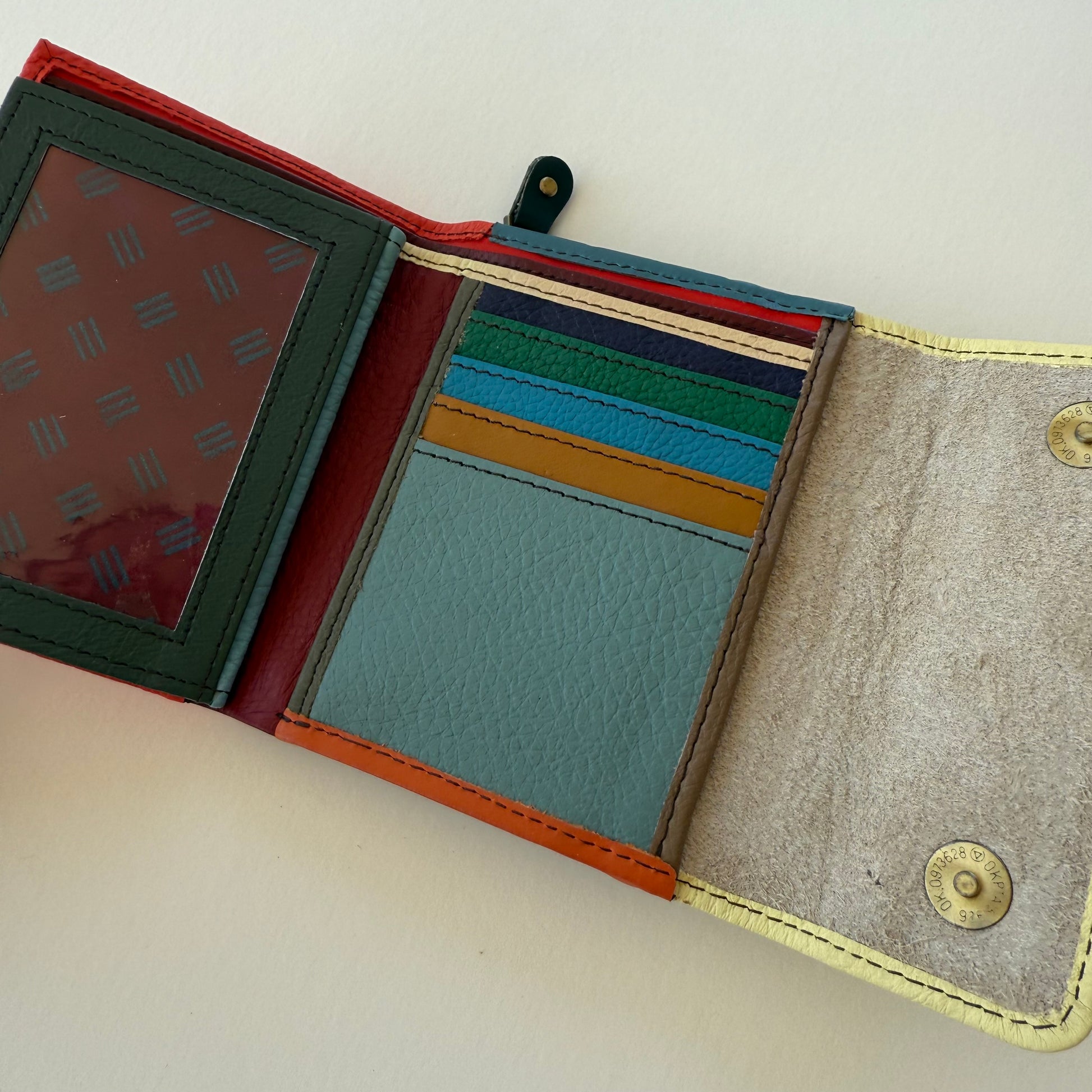 Open leather wallet with various colorful card slots on a light background