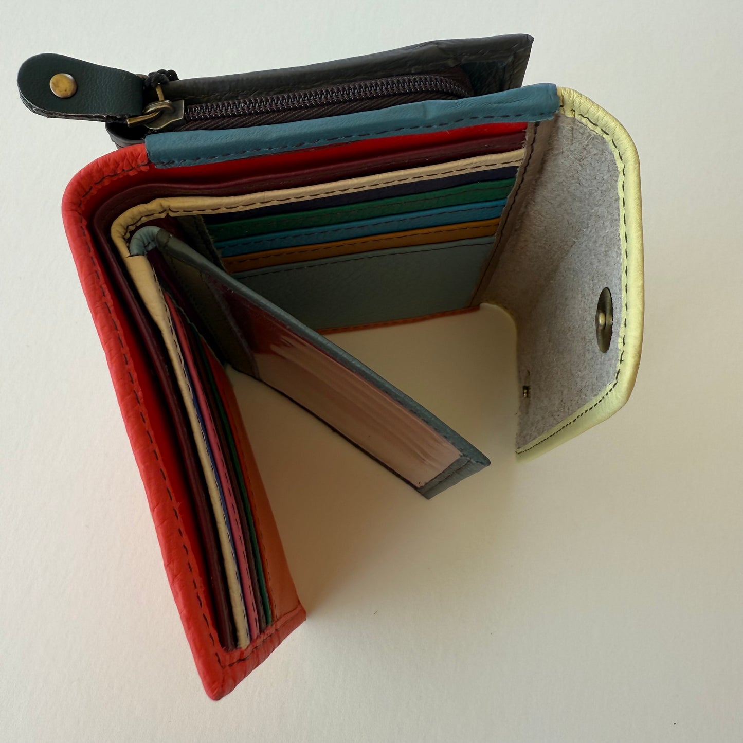top view of Multicolored wallet with a zipper pocket on the back shown on a white background