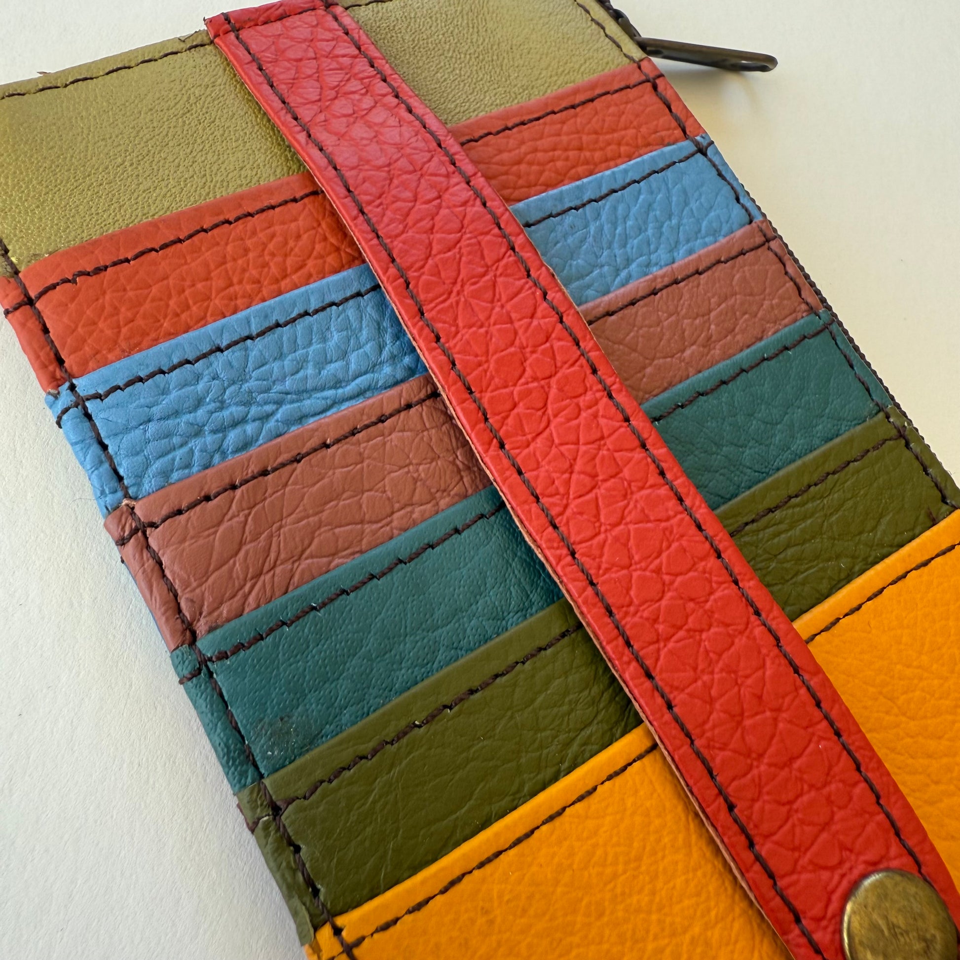 close-up of Colorful leather wallet with a strap on a white background