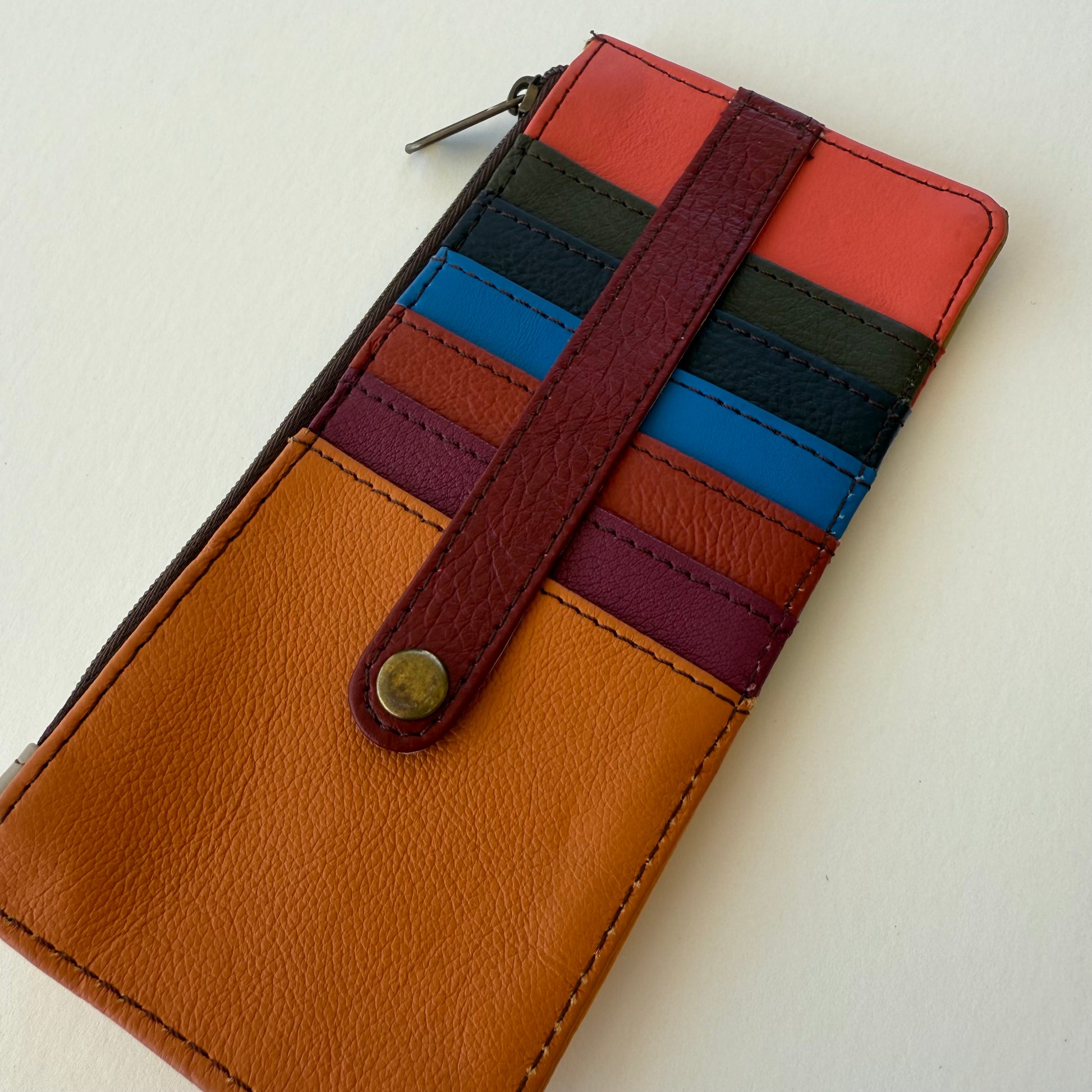 back view of Multicolored leather wallet with a strap on a light background