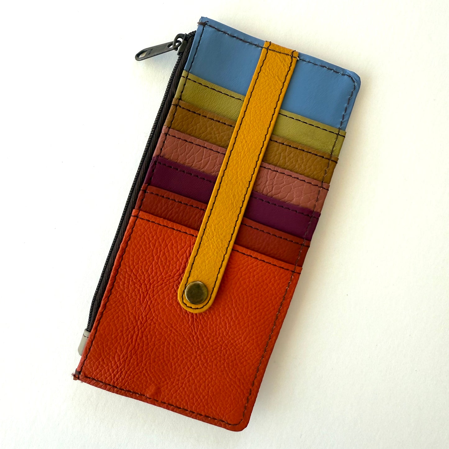 Colorful striped wallet with a yellow strap on a white background