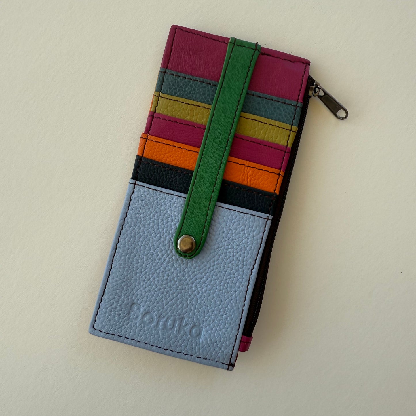 Multicolored wallet with a light blue front and colorful card slots on a beige background