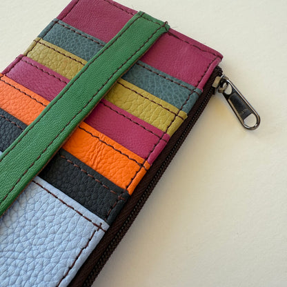 close-up of Colorful striped wallet with a green strap on a light background