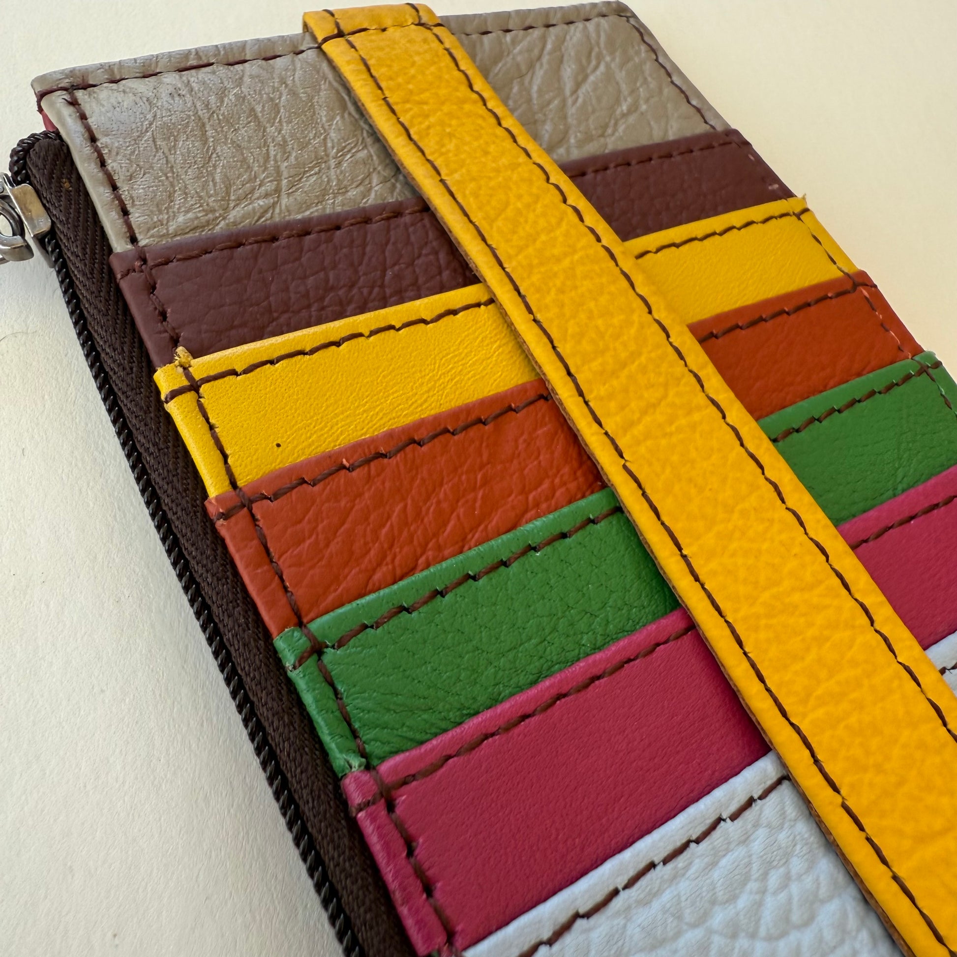 close-up of Colorful leather wallet with a strap on a white background