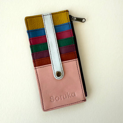 multicolored wallet with colorful card slots and strap over them shown on a white background