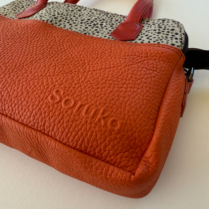 close-up of orange handbag