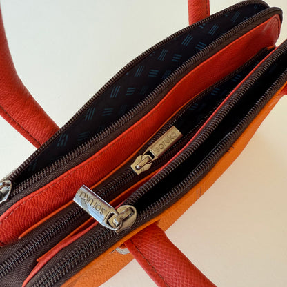 top view of orange handbag with 3 zipper compartments