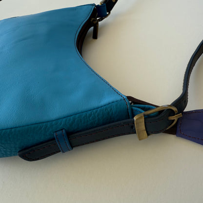 close-up of buckled strap on blue leather handbag