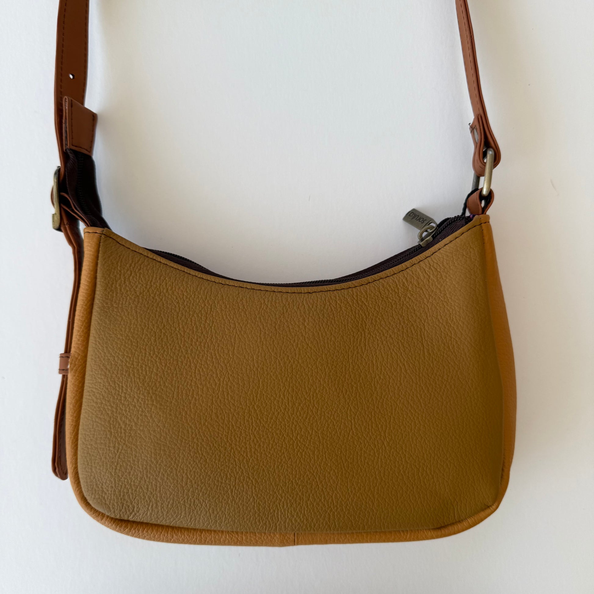 back view of leather handbag in a warm brown
