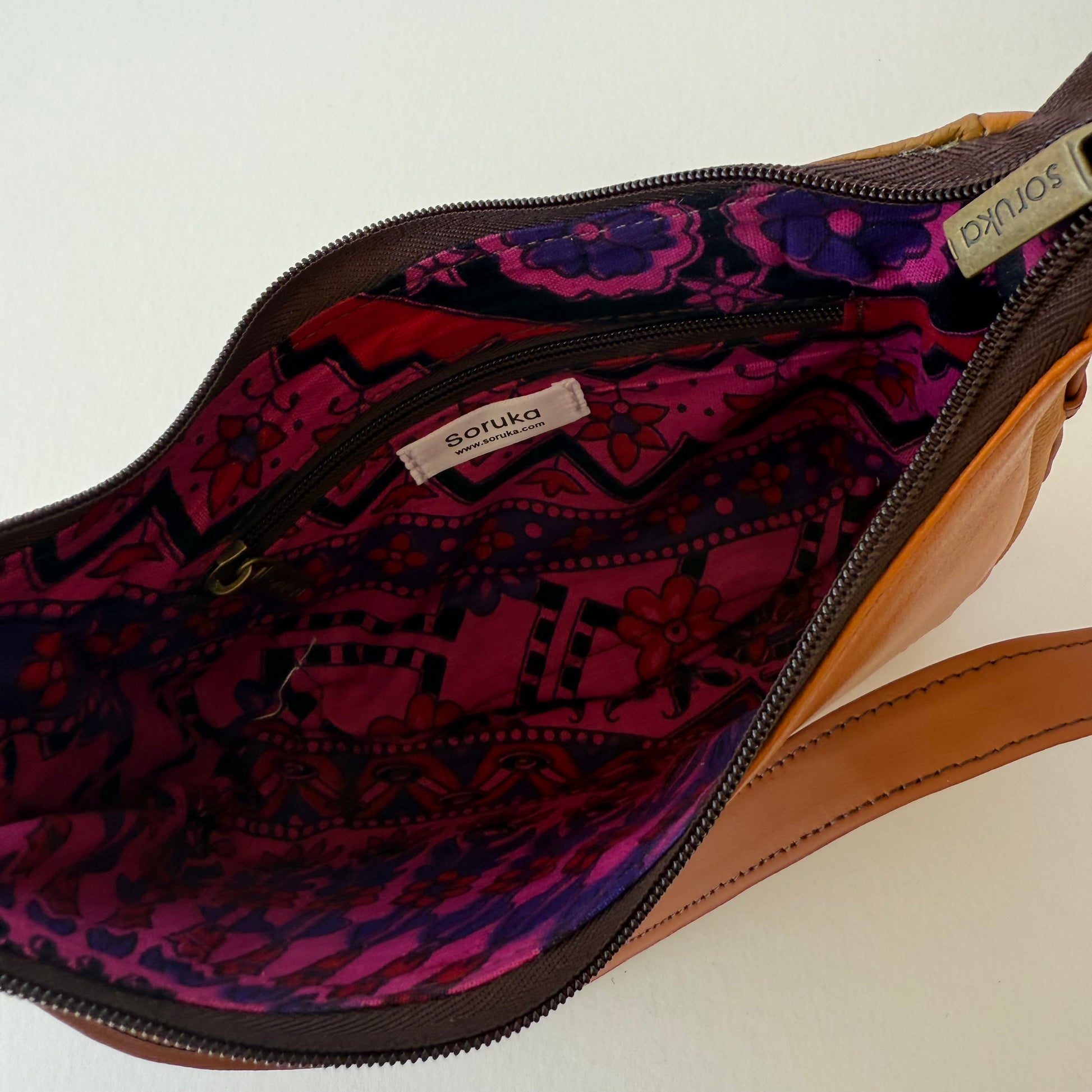 interior view of brown leather handbag showing pink floral lining