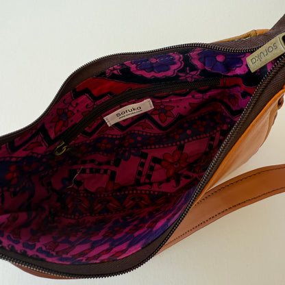interior view of brown leather handbag showing pink floral lining