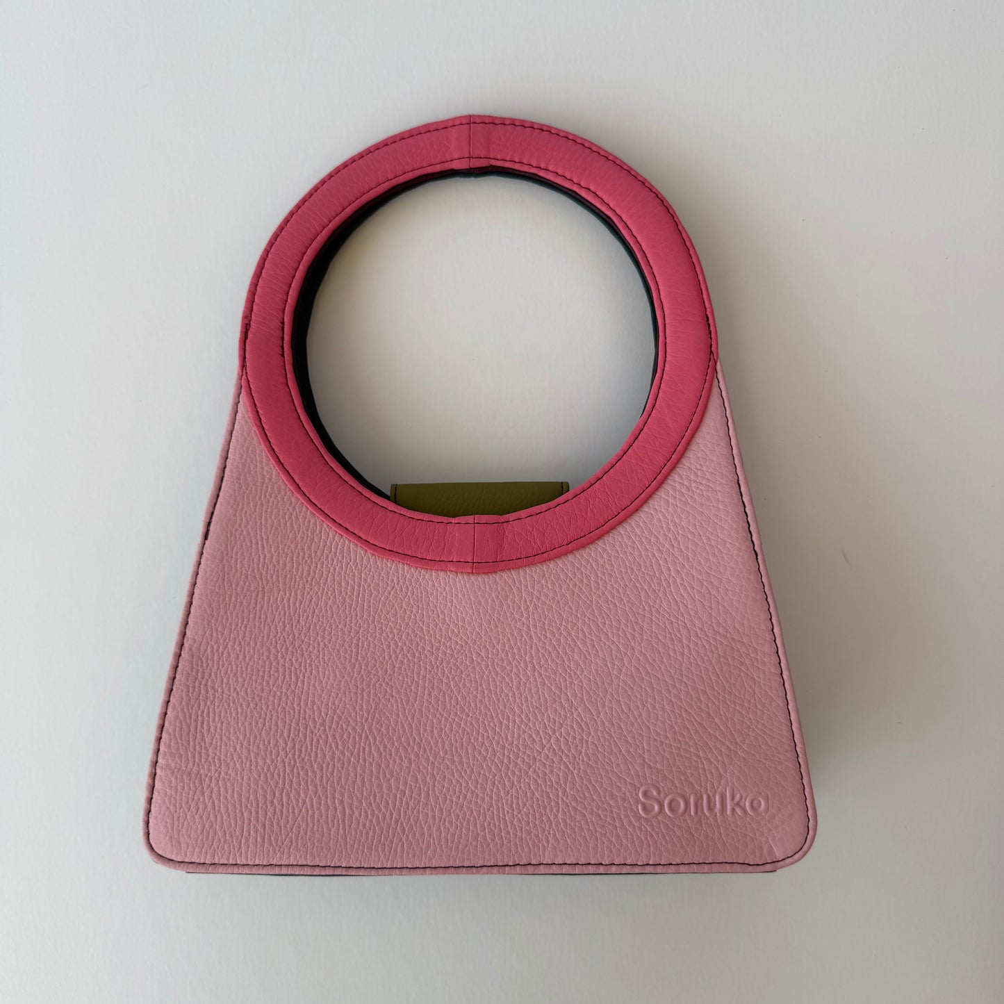 light Pink handbag with bright pink ring handle on a white background