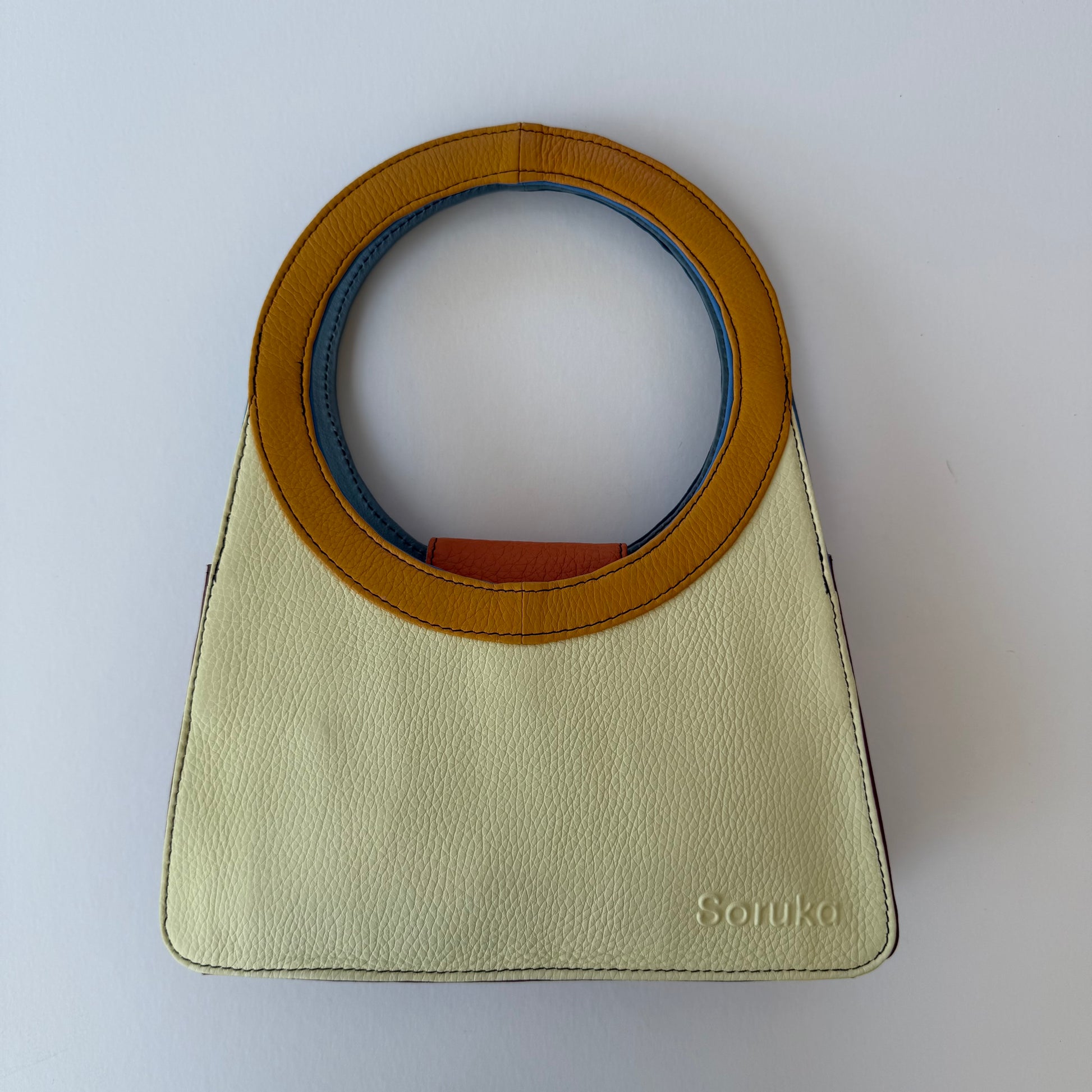 pale yellow handbag with mustard yellow ring handle
