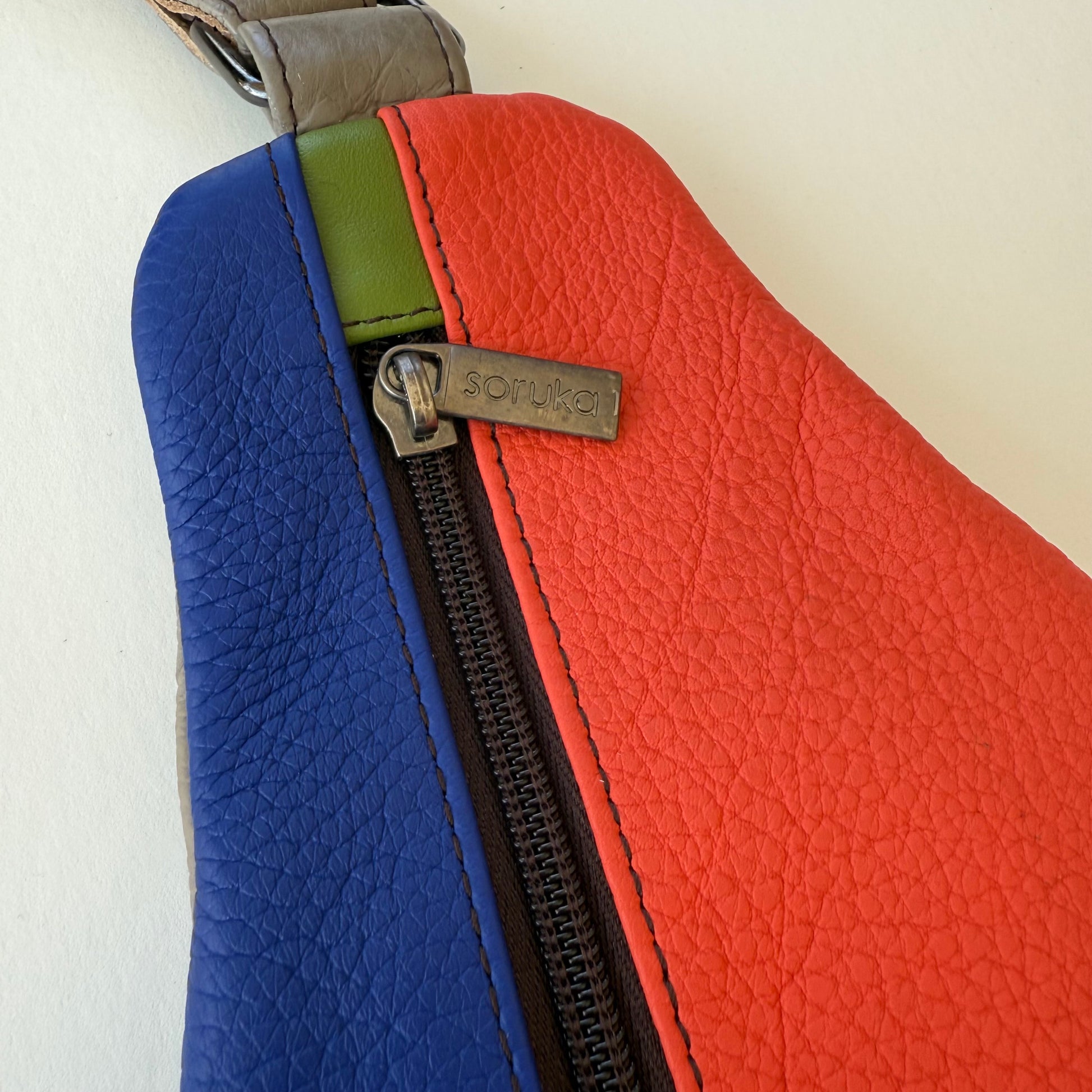 Color-blocked leather bag with zipper 
 on a white background