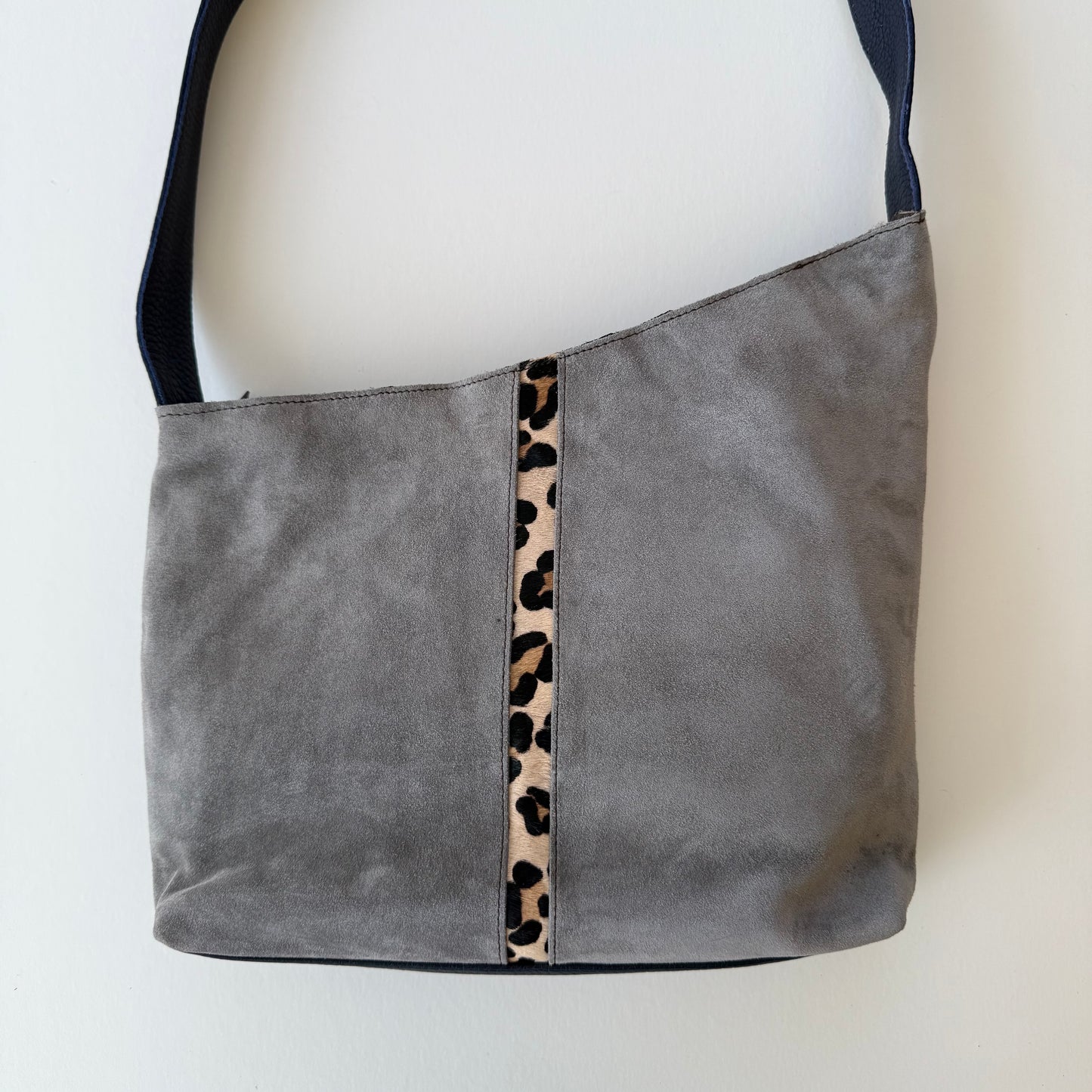 back view of handbag with grey suede backing and cheetah print stripe