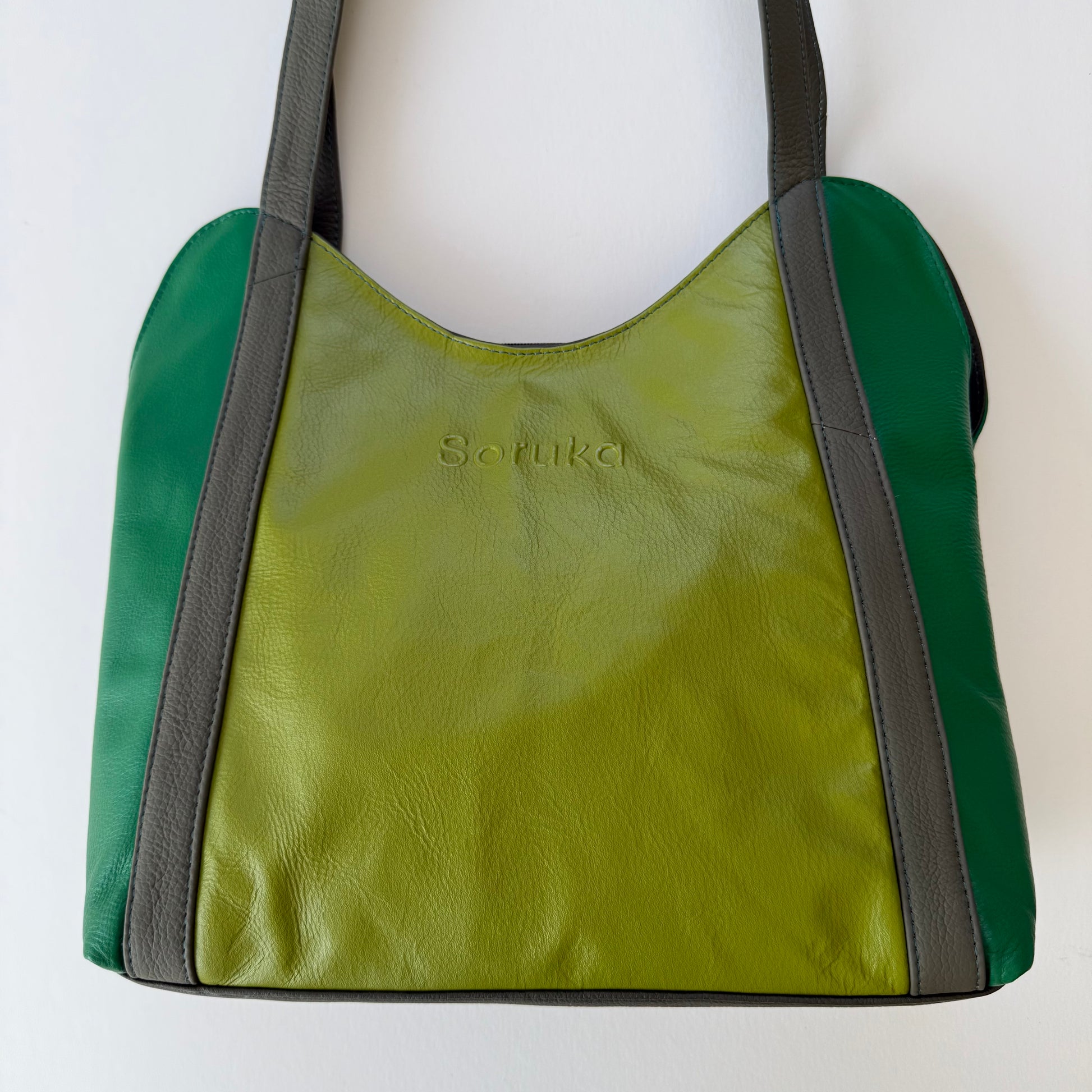 green leather shoulder bag on a white background