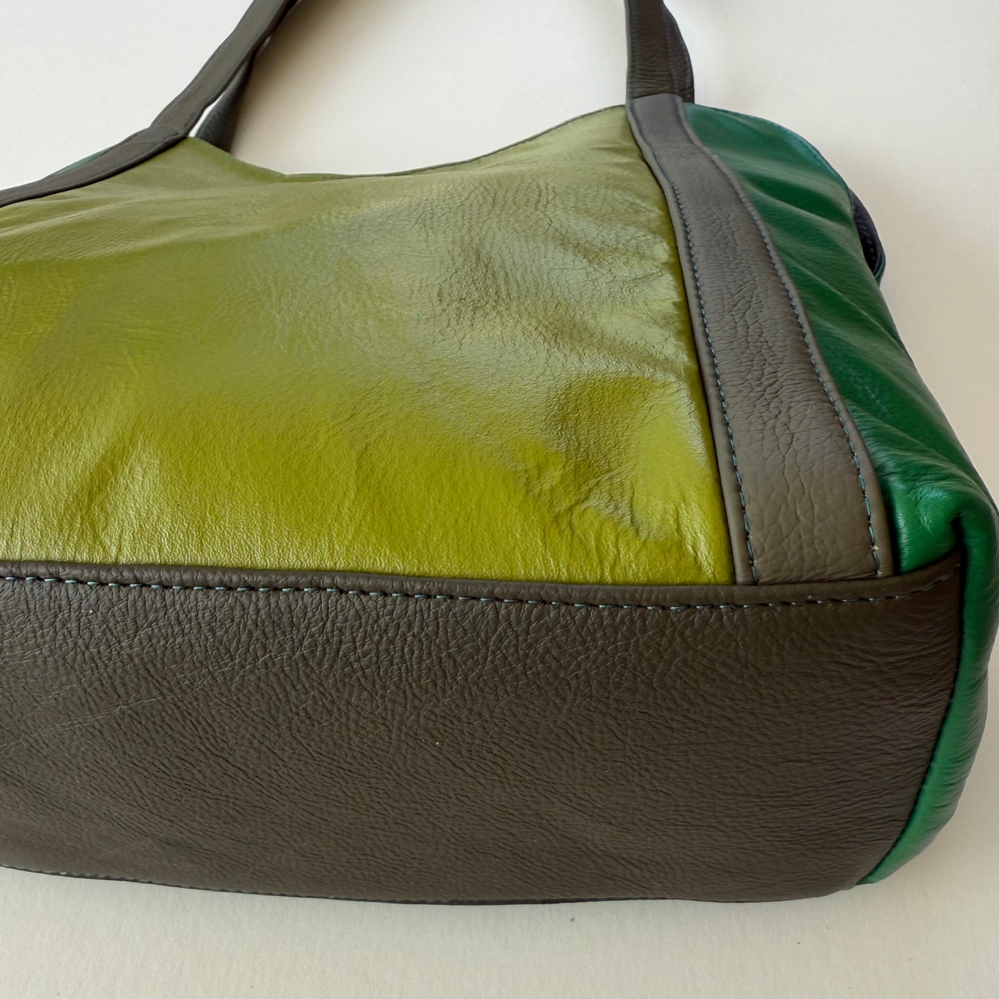 close-up of bottom of green leather shoulder bag