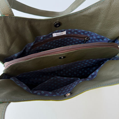 top view of green leather shoulder bag unsnapped