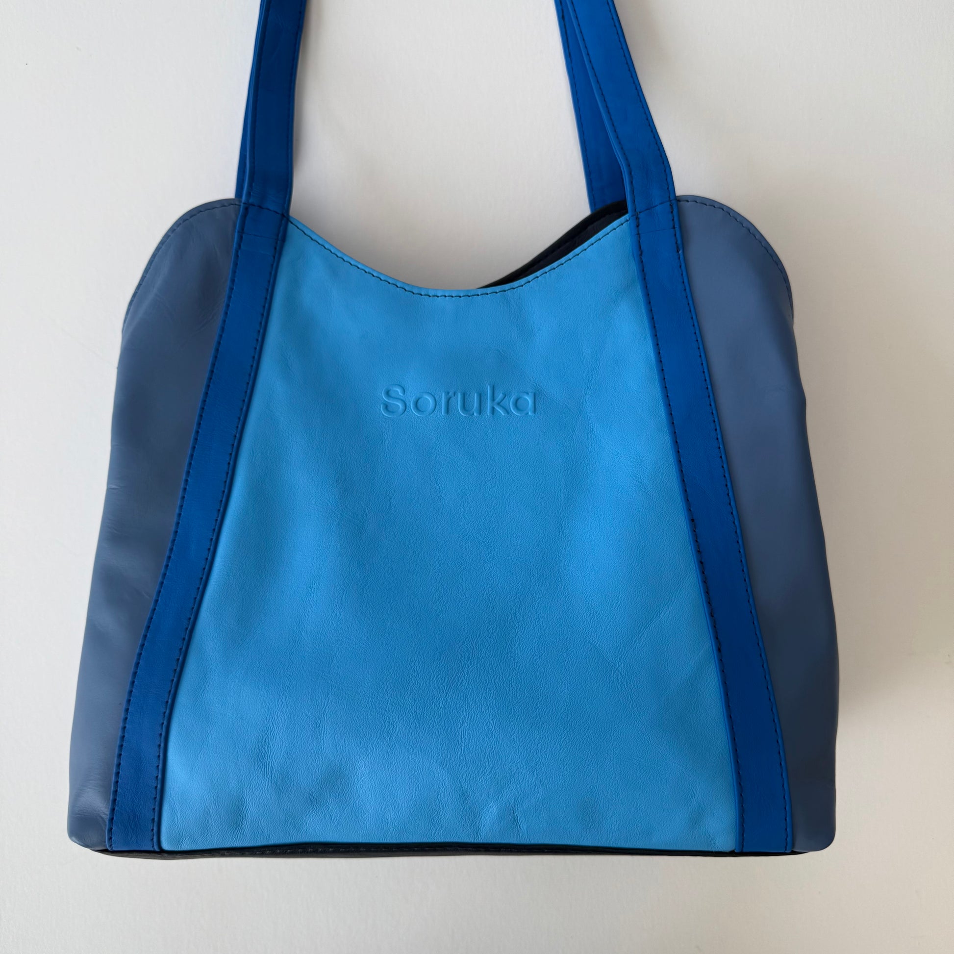 blue leather shoulder bag shown on a white background