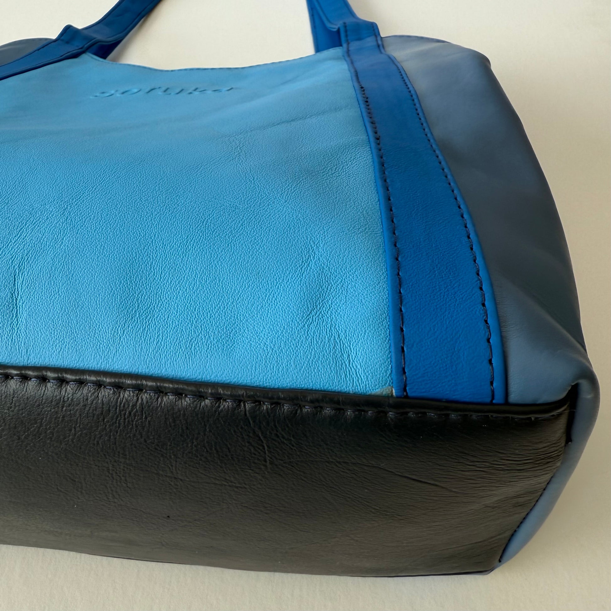 close-up of bottom of blue leather shoulder bag