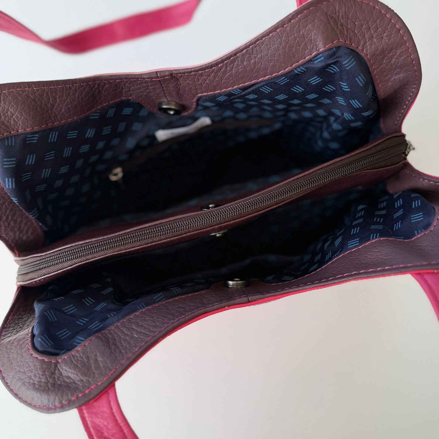 top view of pink leather shoulder bag unsnapped