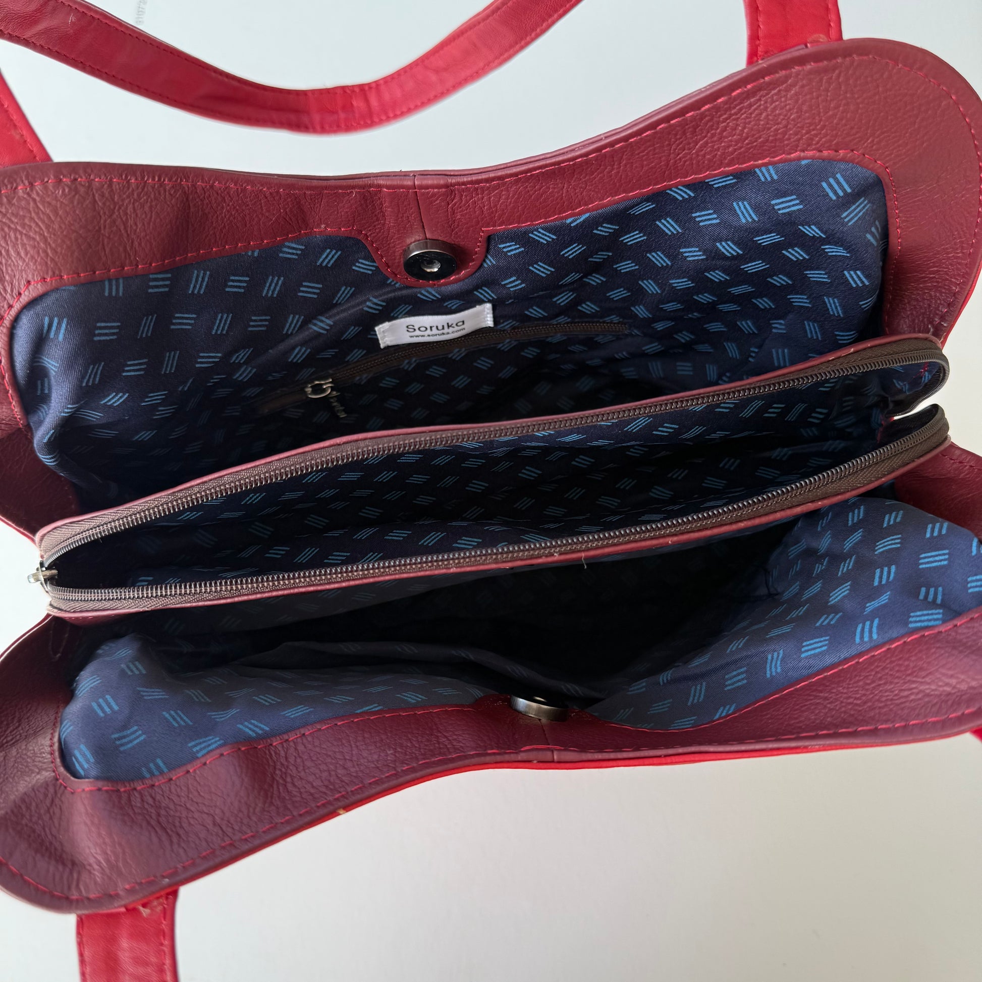top view of red handbag with zipper unzipped