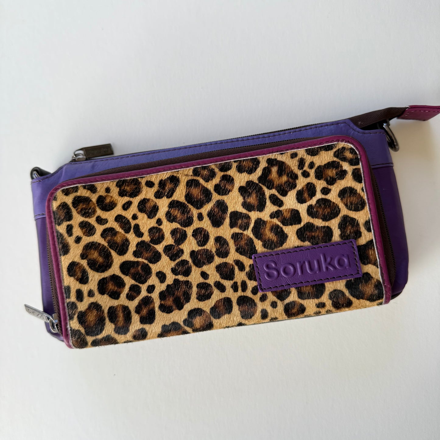 eggplant madison crossbody with purple body and cheetah print front pocket