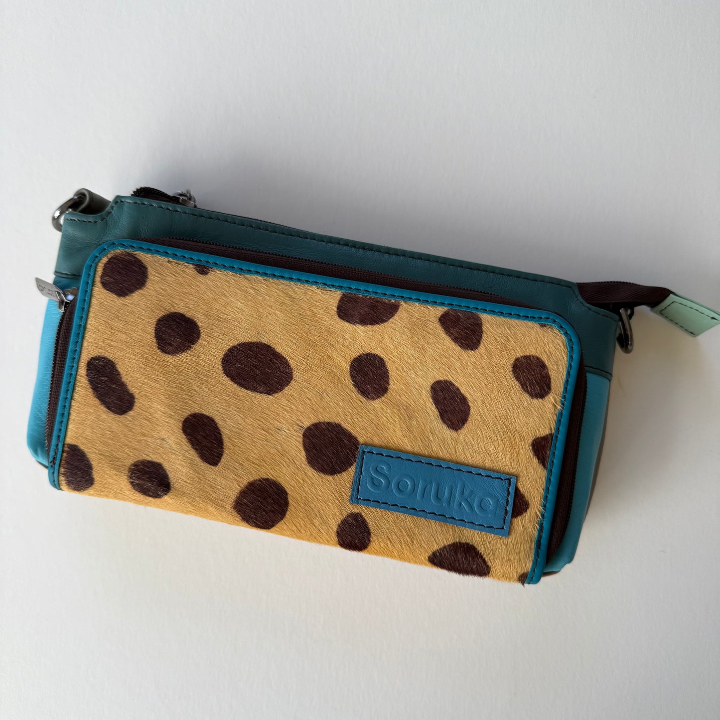 turquoise madison crossbody with blue body and brown on brown animal front pocket