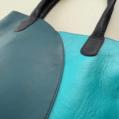 Close-up of a blue and black leather tote bag.