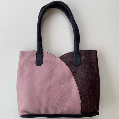 Two-toned tote bag with pink and maroon sections on a light gray background