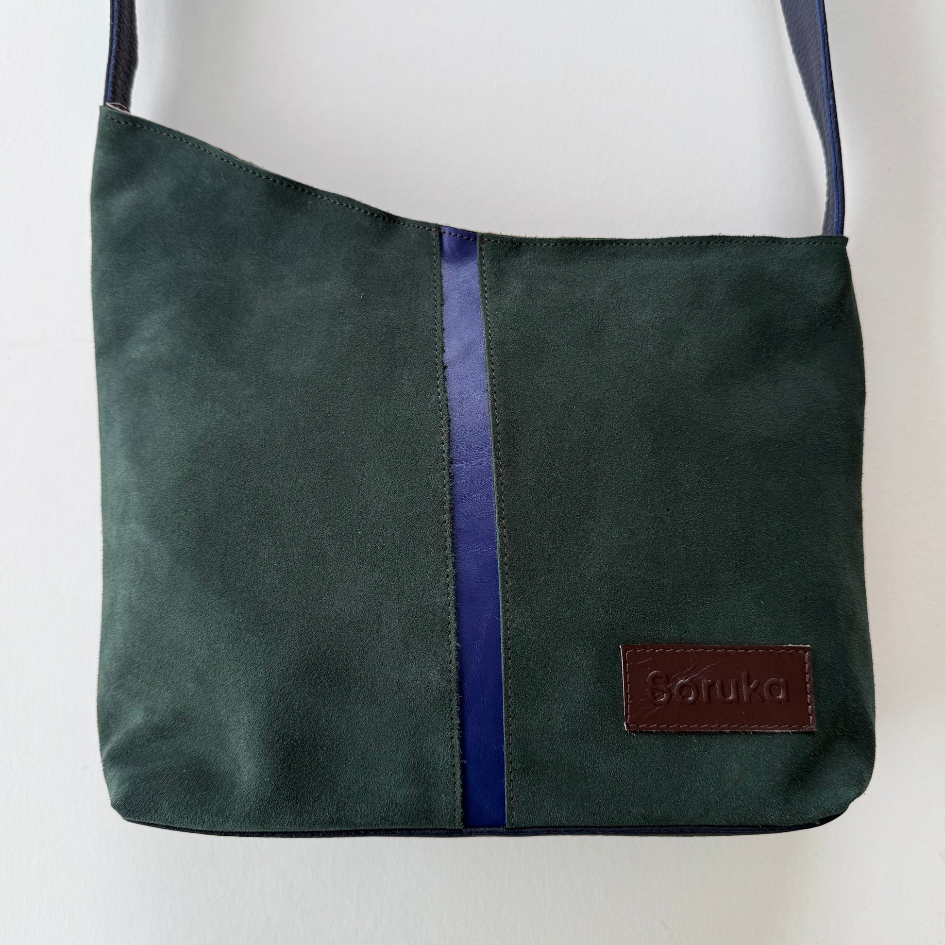 green suede shoulder bag with purple stripe down the middle