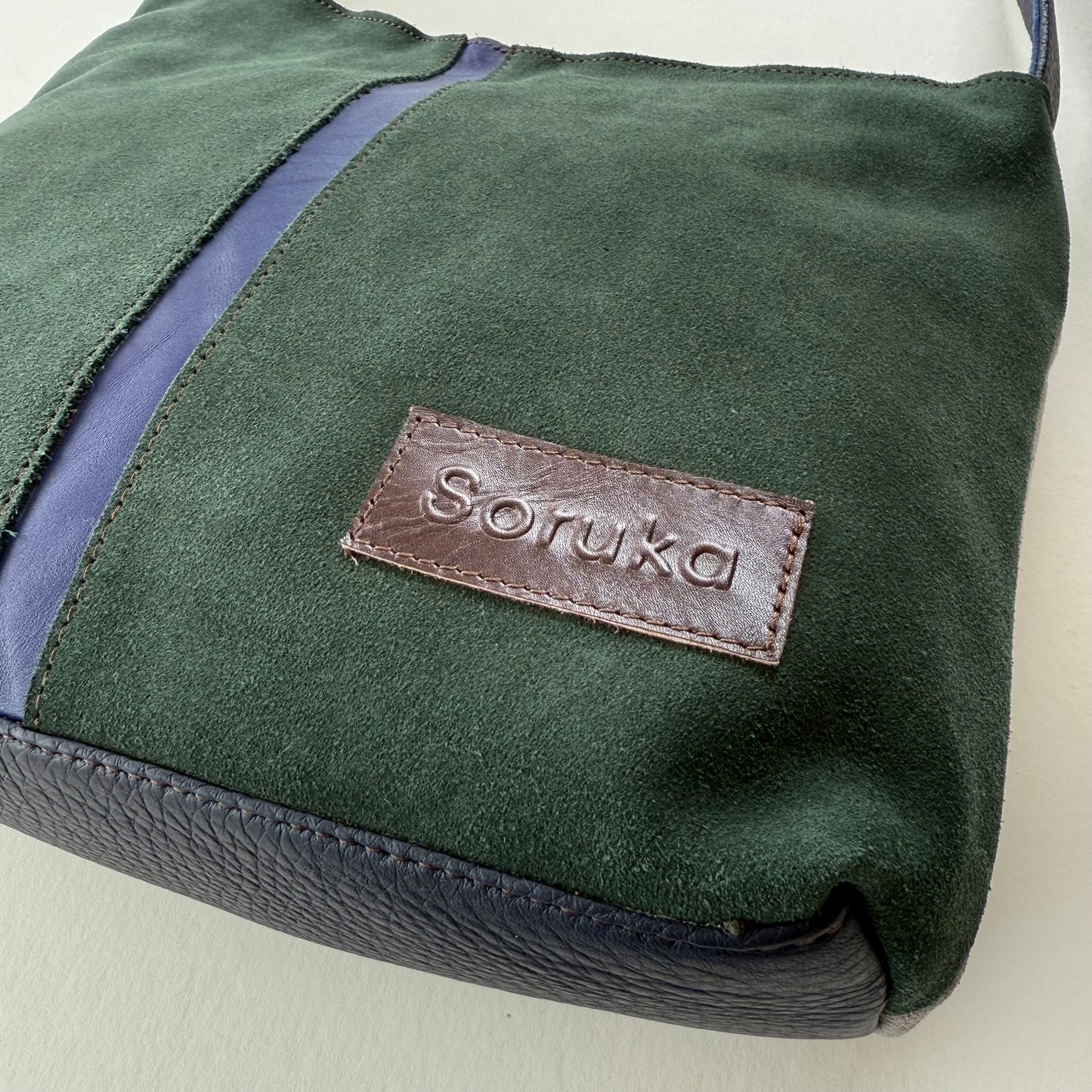 bottom cornet of green and purple handbag