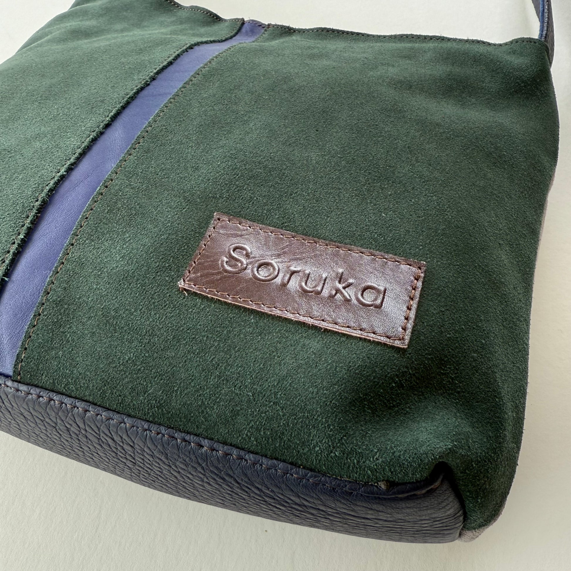 bottom cornet of green and purple handbag