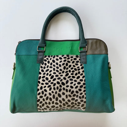 Green patchwork handbag with a animal print section on a white background