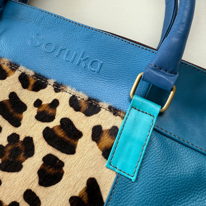 close-up of Blue handbag with leopard print detail 