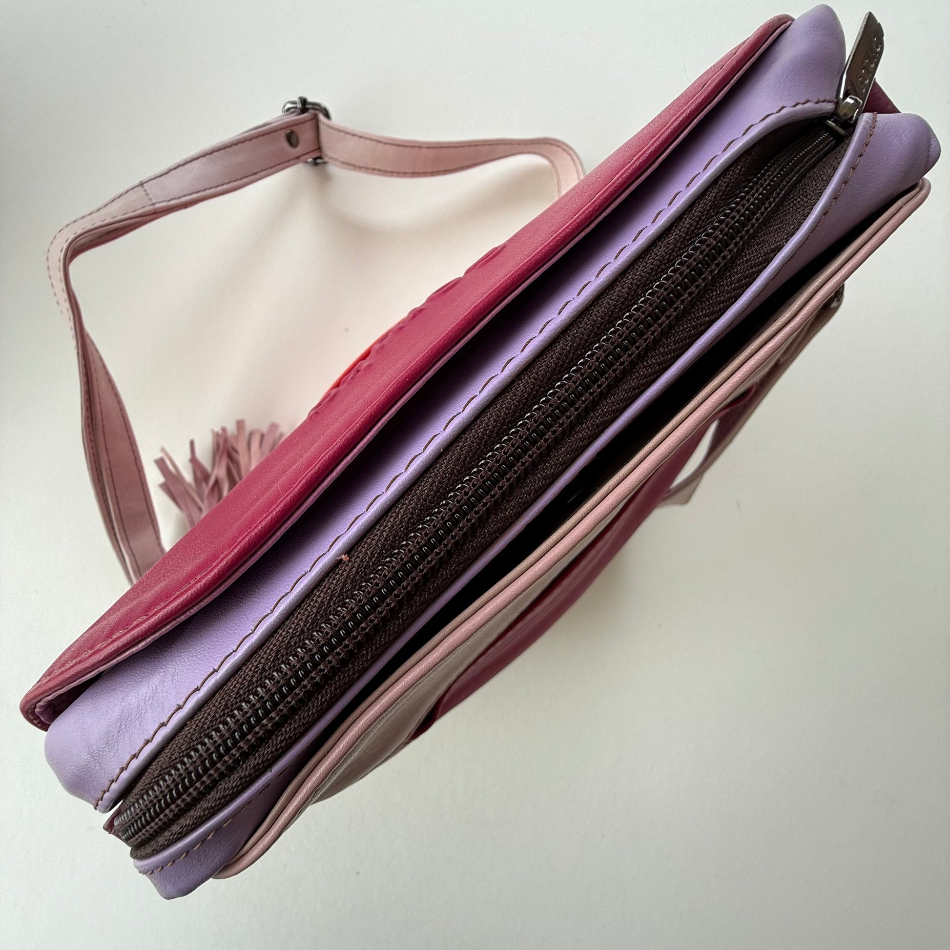 top of pink handbag showing zipper closure and pockets