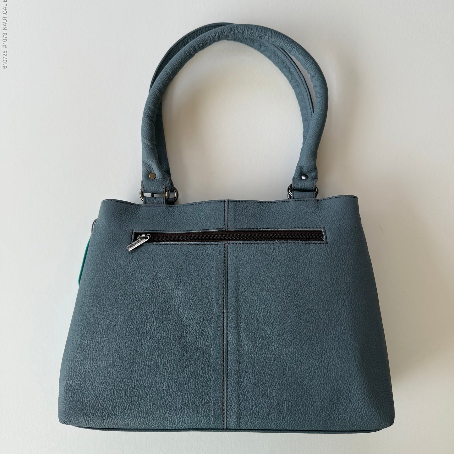 back view of handbag with grey leather backing