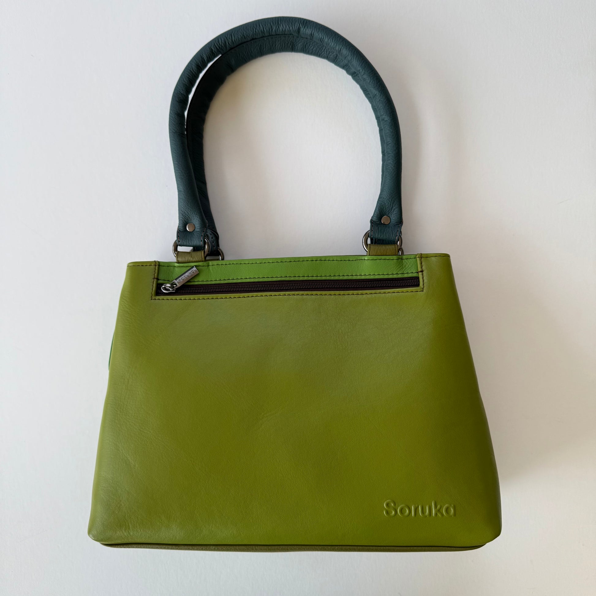 Green handbag with dark green handles on a white background