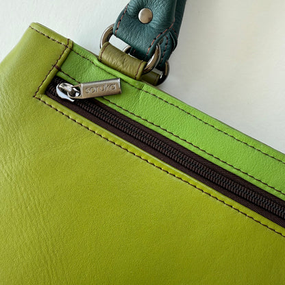 Close-up of a green leather bag with a zippered pocket