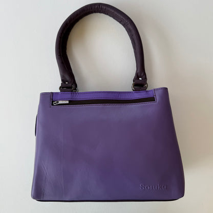 Purple handbag with zipper pocket on a light gray background